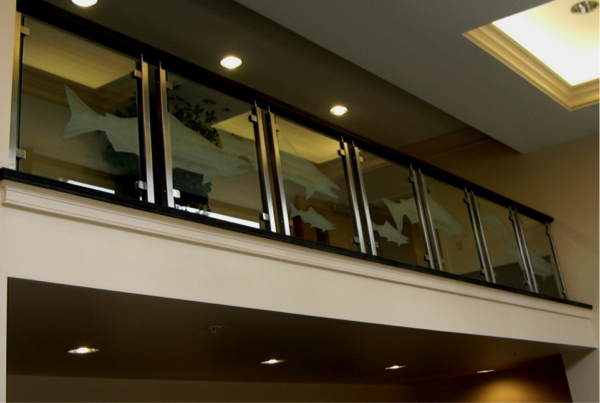 Etched glass railing panel with decorative artwork