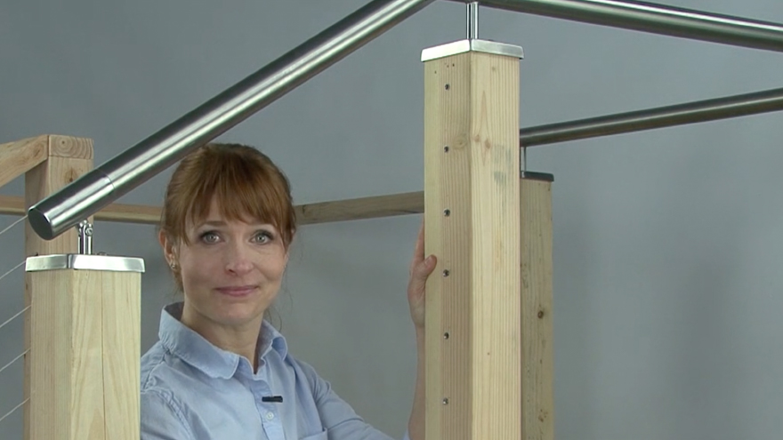 Insert stainless steel cable sleeves into drilled wood railing post holes