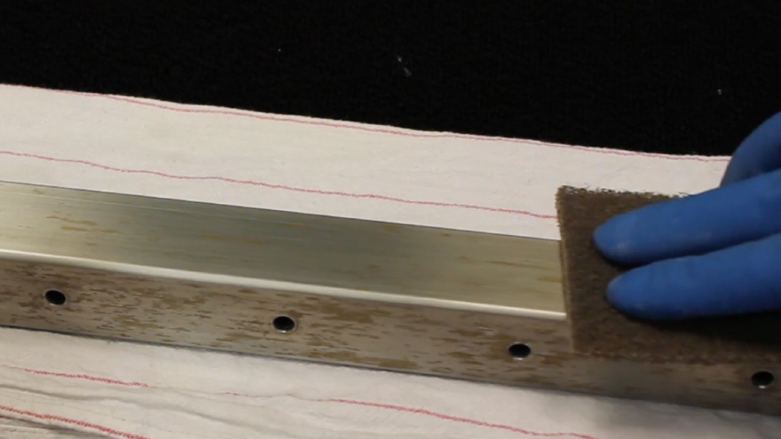 Rub a non-abrasive pad along the stainless steel railing finish