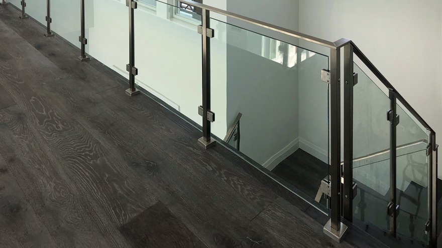 Tempered glass panel railing on stairway. Custom glass stair railing.
