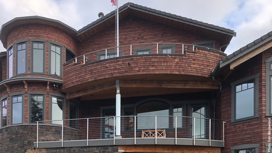 Home featuring two custom railing systems, one on the balcony and one on the deck