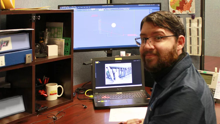 Lead railing system designer Cody sits at his desk