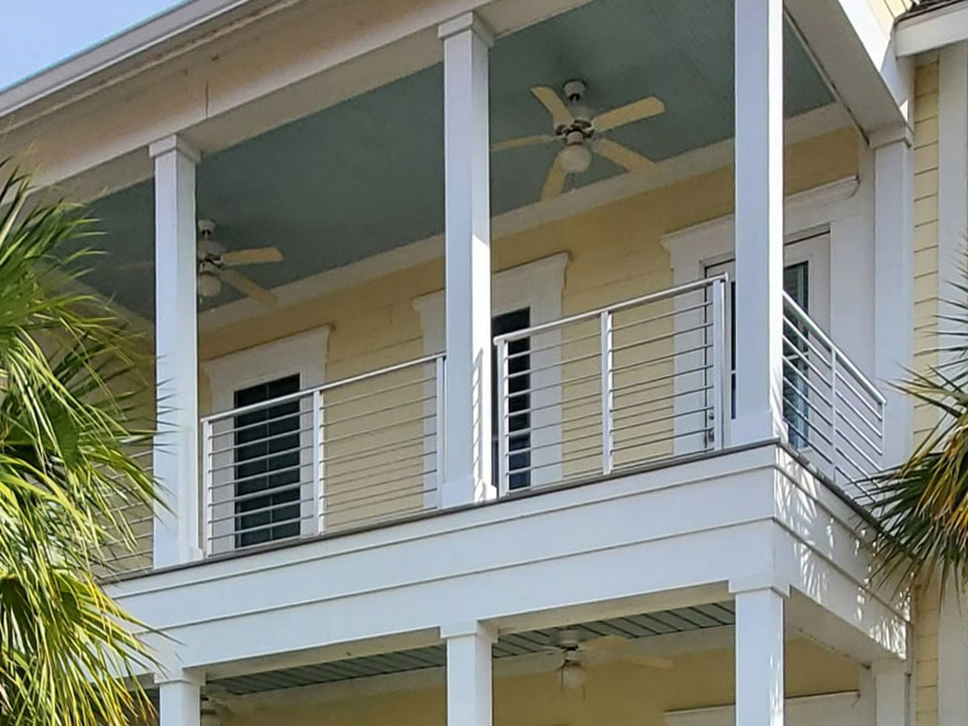 A sleek metal balcony railing paired with rod infill.